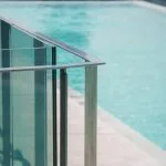 Garde-corps en verre brillant autour d'une piscine ensoleillée