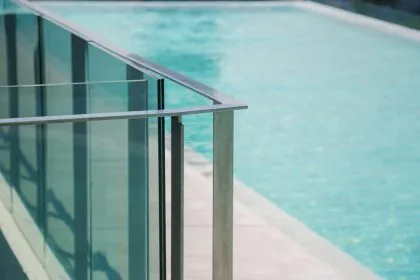 Garde-corps en verre brillant autour d'une piscine ensoleillée