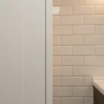 Comparaison entre panneau mural PVC blanc et carrelage céramique blanc dans une salle de bain moderne